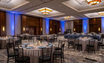 a large banquet hall with multiple tables and chairs set up for a formal event , possibly a wedding reception at Hyatt Regency Coralville Hotel & Conference Center