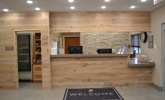 a modern hotel lobby with a reception desk , a welcome mat , and a coffee machine at Country Inn & Suites by Radisson, Fairview Heights, IL