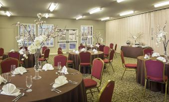 a large dining room with multiple tables and chairs arranged for a formal event , possibly a wedding reception at London Bridge Resort