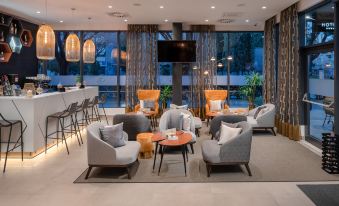 a modern lounge area with a variety of seating options , including couches , chairs , and a television at Sia Split Hotel