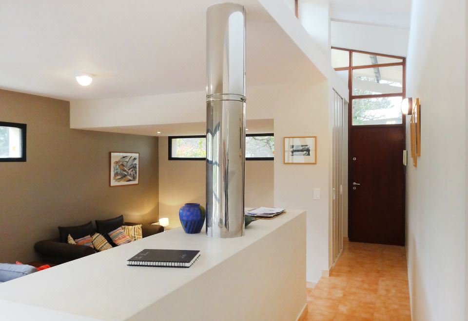a modern kitchen with a white countertop and stainless steel refrigerator , along with a dining area and living room in the background at Holiday Home Villa Isabelle
