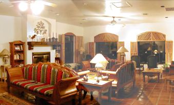 a cozy living room with a fireplace , comfortable seating , and a view of the outdoors at Casa de San Pedro Bed & Breakfast