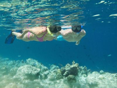 two people are snorkeling in the ocean , with one of them wearing goggles and the other wearing goggles at Vilamendhoo Island Resort & Spa