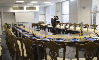 a conference room with a long table , chairs , and a tv screen set up for an event at Park Hotel Bellevue