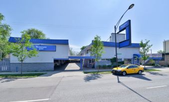 A car is parked in front of the entrance to an old-fashioned gas station that is painted blue and white at Rodeway Inn Chicago