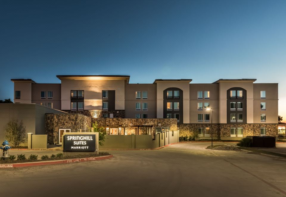 "a large building with a stone wall and the name "" springfield suites "" written on it" at SpringHill Suites Dallas Rockwall