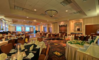 a large , well - lit dining room filled with tables and chairs , ready for a group of people to enjoy a meal at Hilton Garden Inn Laramie