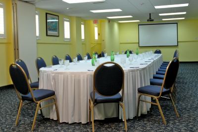 a conference room set up for a meeting , with tables and chairs arranged in a semicircle at Wyndham Reef Resort Grand Cayman