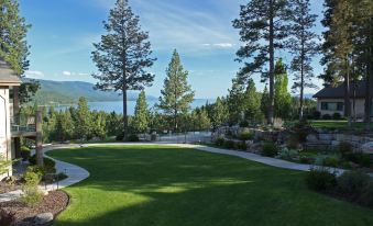 a large , well - maintained lawn with trees and a lake in the background , creating a serene and picturesque scene at Mountain Lake Lodge