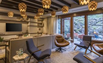 a modern living room with a gray couch , chairs , and pendant lights hanging from the ceiling at Skamania Lodge