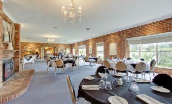 a large dining room filled with tables and chairs , ready for guests to enjoy a meal at Parkes International