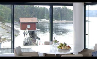 a dining table with a view of a lake , and a couple standing near the water at Son Spa, an Ascend Member