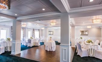 a large , elegant banquet hall with multiple tables and chairs set up for a formal event at Danfords Hotel & Marina