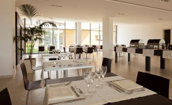 a large , open dining area with multiple tables and chairs arranged for a group of people to enjoy a meal at Inn Naples Airport