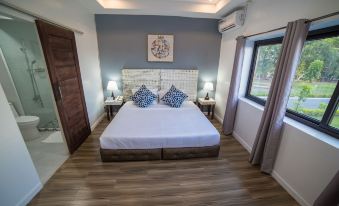 a modern bedroom with wooden flooring , white bed sheets , and two nightstands on either side of the bed at The Mansion