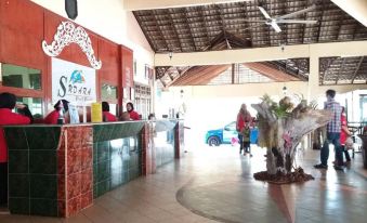 There is a restaurant on the ground floor with people standing at the counter, as well as another restaurant on the top floor at Hotel Sudara Beach Resort