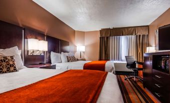 a hotel room with two beds , one on the left and one on the right side of the room at Best Western Plus Butte Plaza Inn