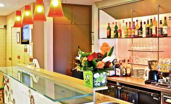 a modern bar with a marble counter , multiple bottles of liquor on display , and red pendant lights at Ibis Epinay Sur Seine - Gennevilliers