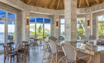 a modern restaurant with marble floors , high ceilings , and large windows offering views of the ocean at Reefhouse Resort and Marina