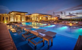 a large outdoor pool surrounded by lounge chairs and umbrellas , providing a relaxing atmosphere for guests at The Vines Resort & Spa