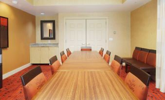 a long wooden conference table with orange chairs and a white cabinet in the background at Residence Inn Princeton at Carnegie Center