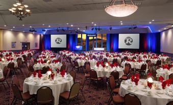 a large banquet hall filled with tables and chairs , ready for a formal event or a wedding reception at Bismarck Hotel and Conference Center