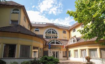 "a large yellow building with a sign that reads "" hotel "" prominently displayed on the front of the building" at Hotel Arboretum