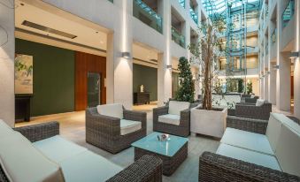 a modern , well - lit living room with comfortable couches and chairs arranged around a coffee table at Admiral Grand Hotel