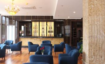 a well - lit bar area with several chairs and couches , creating a comfortable and inviting atmosphere at Phoenix Hotel