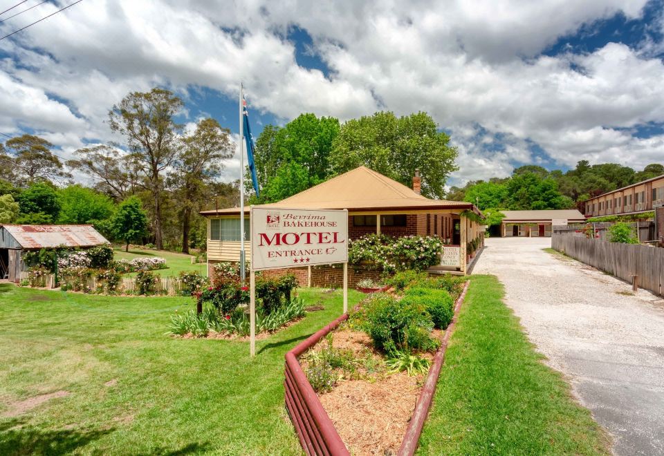 "a building with a sign that says "" beaumont motel "" and has green grass in front of it" at Berrima Bakehouse Motel