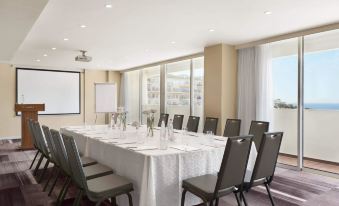 a conference room set up for a meeting , with chairs arranged in a rectangular formation and a whiteboard on the wall at Resort Hadera by Jacob Hotels