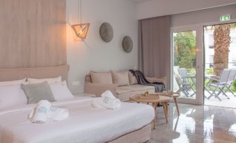 a cozy bedroom with a white bed , a couch , and a window overlooking a patio at Minthi Boutique Apartments