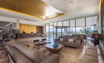 a spacious , well - lit living room with multiple couches and chairs arranged around a coffee table at Zafiro Palace Alcudia