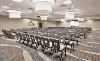 a large conference room with rows of chairs arranged in a semicircle , and a projector screen on the wall at Courtyard Columbus Phenix City/Riverfront