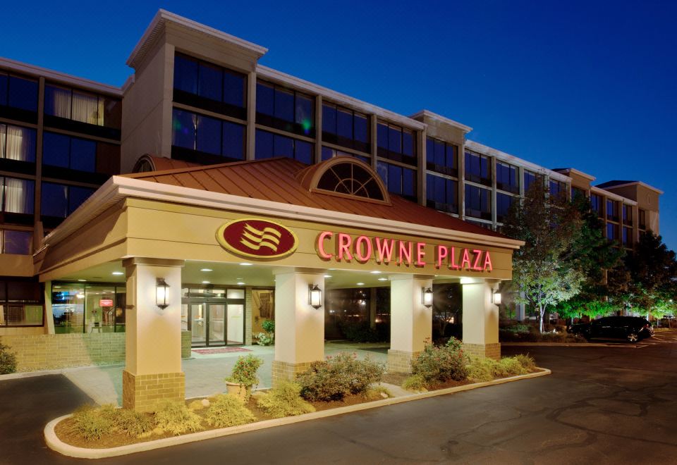 a crowne plaza hotel building at night , with its name displayed in large letters above the entrance at Crowne Plaza Cleveland Airport