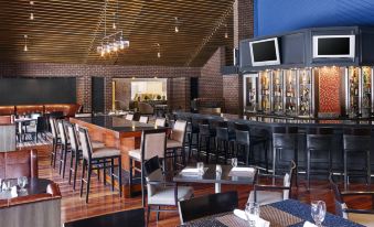 a bar with a variety of chairs and tables , a television , and a large screen at Delta Hotels by Marriott Baltimore Hunt Valley