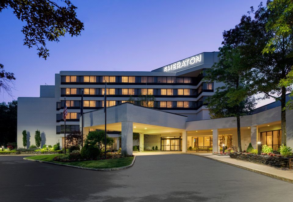 a large hotel building with a large sign on the front , surrounded by trees and other buildings at Portland Sheraton at Sable Oaks