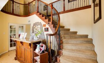 a wooden staircase with a railing and a counter at the top of the stairs at Dream Manor Inn