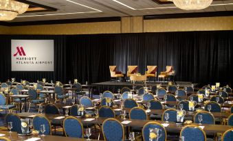 a large conference room set up for a meeting , with chairs arranged in rows and a projector screen on the wall at Atlanta Airport Marriott