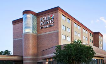 a four points by sheraton hotel with its name displayed on a brick building , and its exterior design is visible at Four Points by Sheraton Winnipeg South
