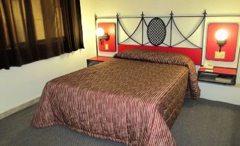 a bedroom with a red and black bed frame , a brown comforter , and a window at Hotel San Francisco