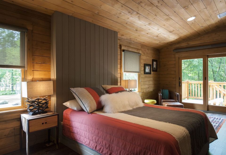 a cozy wooden bedroom with a large bed and multiple pillows , creating a warm and inviting atmosphere at Chatfield Hollow Inn