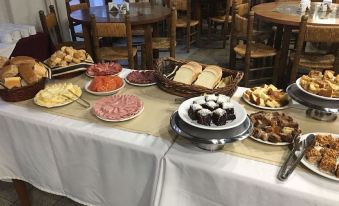 a dining table filled with an assortment of food items , including sandwiches , pastries , and desserts at Hotel Hermitage