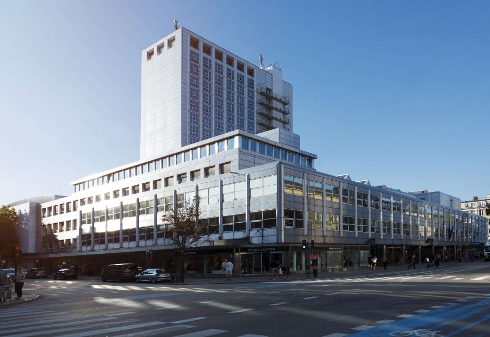 a large white building with a large glass facade is situated on a street corner at Scandic Falkoner