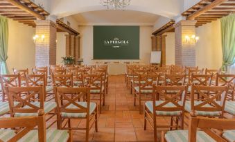 a conference room with wooden chairs arranged in rows and a green screen on the wall at Hotel Ristorante la Pergola