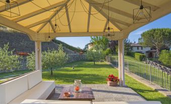 a backyard with a wooden deck , a gazebo , and a dining table set up for outdoor dining at Arco