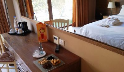 a hotel room with a bed , a table , and various items on it , including snacks and a remote control at Valley Village