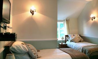 a bedroom with two beds , one on the left and one on the right side of the room at The Bell Inn