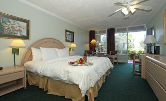 a large bed with white linens and a tray of fruit on top of it at Grand Palms Spa & Golf Resort