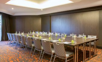 a large conference room with multiple tables and chairs , each set up for a meeting or event at Novotel Sydney Darling Harbour